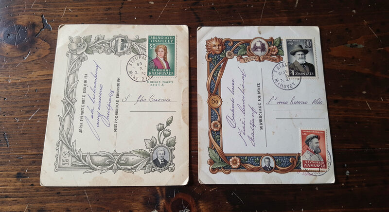 Two old postcards side by side showing different borders and print styles on a dark wooden table.